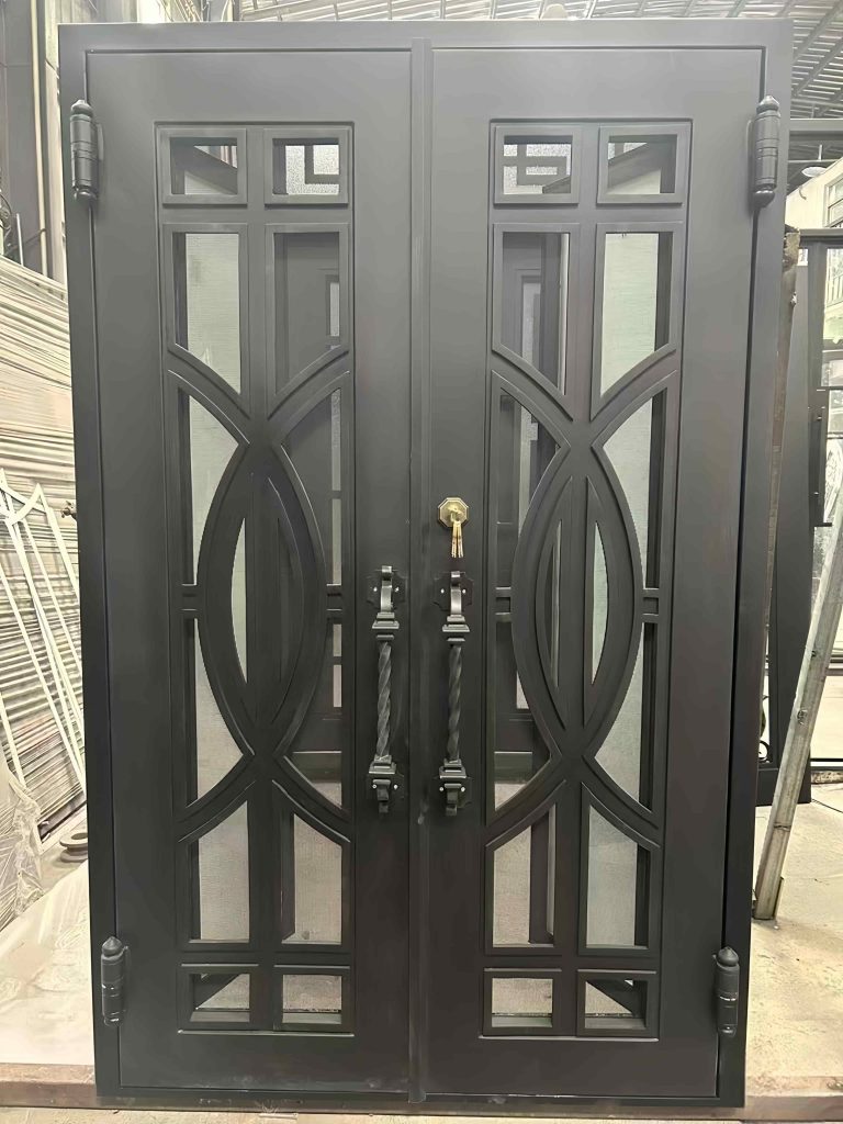 A Premium Cast Iron Spiral Staircase by Like Metal features geometric and curved metalwork, glass elements, and ornate design details, showcased in an industrial workshop setting.