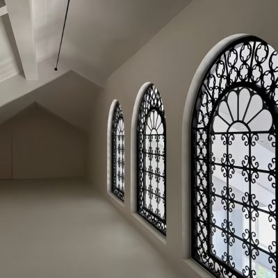 Custom black wrought iron window with hand-forged grilles and clear tempered glass – luxury villa security window design
