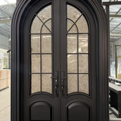 Elegant black arched double doors with glass panels in a workshop setting