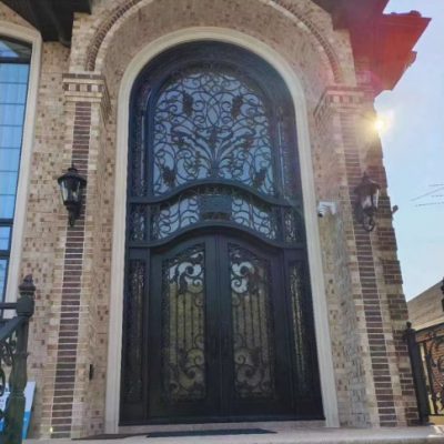 French-style handcrafted wrought iron gate with floral ornaments and arched top for garden entrance