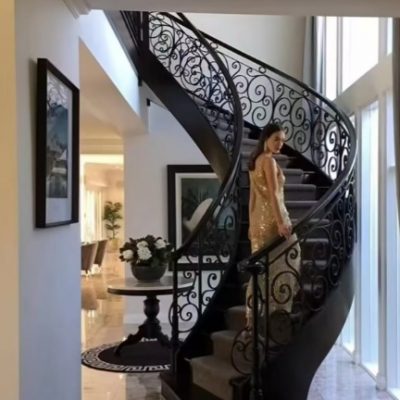 Full view black wrought iron spiral staircase from floor to ceiling in modern loft interior