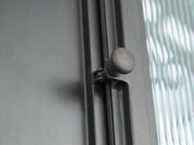 LIKE Metal hinged glass door lock featuring a sturdy stainless steel body, sleek modern design, key cylinder, and heavy-duty latch mechanism, professionally mounted on a tempered glass door for commercial and residential applications.