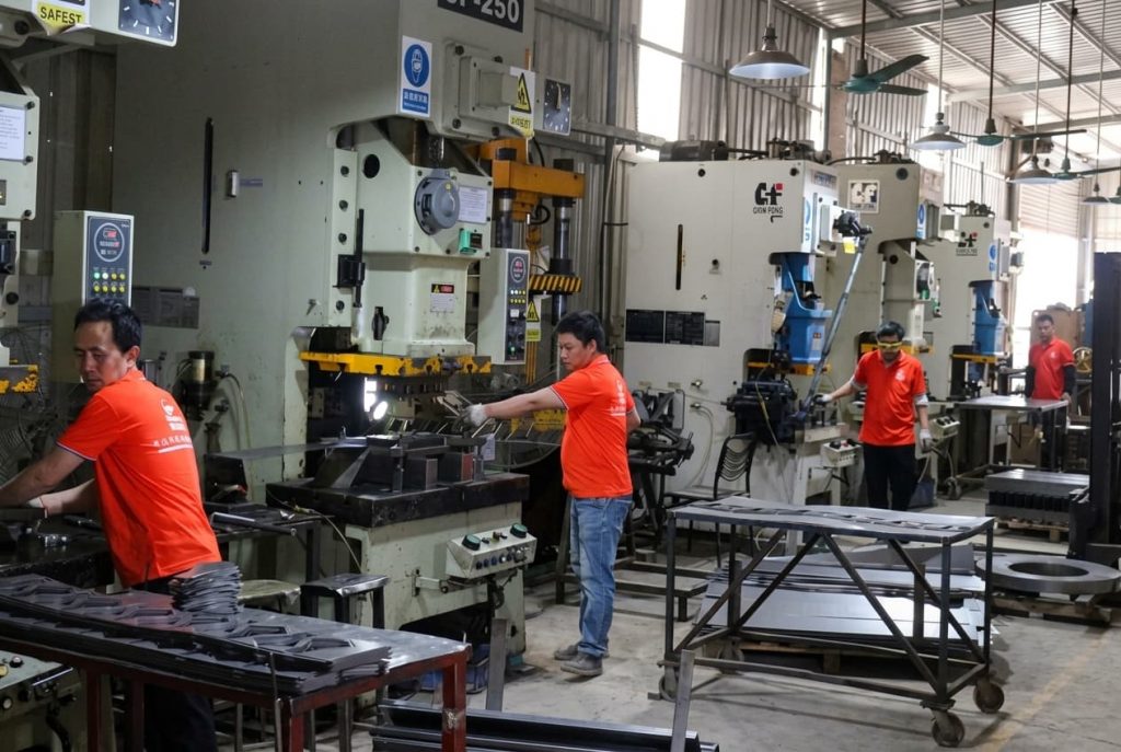 Spacious LIKE Metal table leg production workshop with automated cutting and bending machines, robotic welding stations, PVD coating lines, and skilled workers assembling various metal table leg styles, with finished products neatly stacked for quality inspection and packaging.